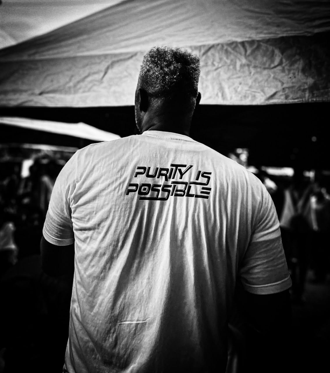 Evangelist Kesiena Esiri at an outreach wearing a Purity Is Possible shirt
